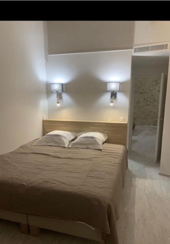 une chambre avec un grand lit avec deux oreillers dans l'établissement Chante Brise 2 Pieces, à Cannes