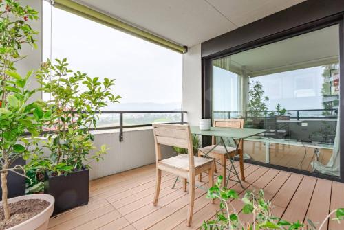 an apartment balcony with a table and a window at DynastyConcept Luxury in Rotkreuz