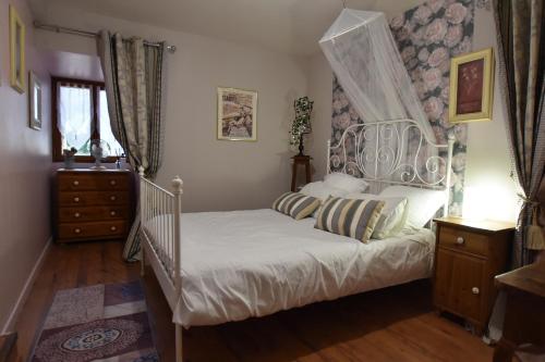 une chambre avec un lit blanc à baldaquin dans l'établissement Les Girouteaux La bergerie, à Les Eyzies-de-Tayac