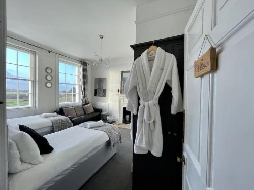 a bedroom with a robe hanging on a door at Uplands House Tewkesbury in Tewkesbury