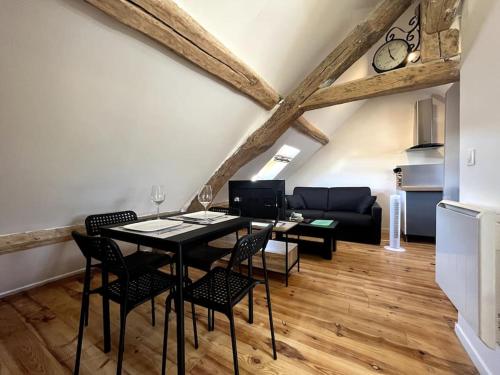 un salon avec une table, des chaises et un canapé dans l'établissement Climber's Loft with Netflix, à Montcourt-Fromonville
