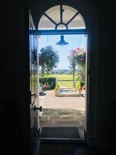 an open door with a view of a yard at Uplands House Tewkesbury in Tewkesbury