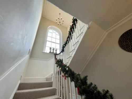 a staircase with christmas garland and a window at Uplands House Tewkesbury in Tewkesbury