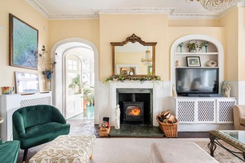 a living room with a fireplace and a tv at Uplands House Tewkesbury in Tewkesbury