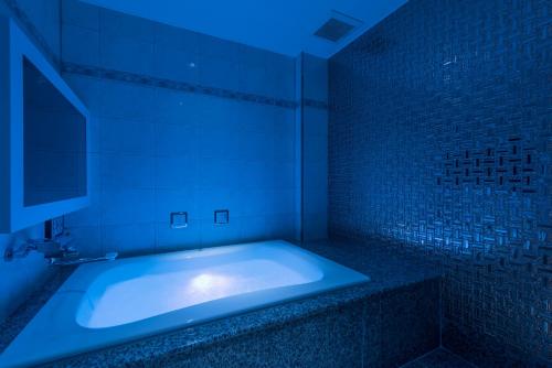 a bathroom with a tub with a blue light at ホテルディオールセブン郡山 in Koriyama