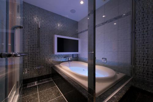 a bathroom with a tub with a tv in it at ホテルディオールセブン郡山 in Koriyama