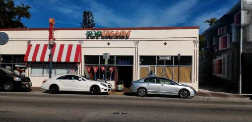 two white cars parked in front of a store at Coco Sol 2 by MyMiamiStay in Miami