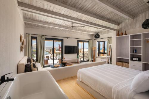 a bedroom with a large white bed and a tub at Marmarica Boutique Cabanas - Ras El Hekma - North Coast Top Rated Luxury Stay in Marsa Matruh