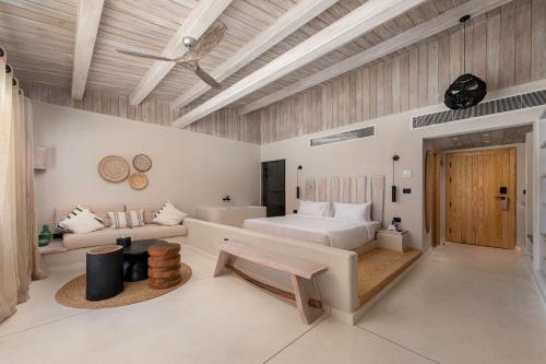 a white bedroom with a bed and a couch at Marmarica Boutique Cabanas - Ras El Hekma - North Coast Top Rated Luxury Stay in Marsa Matruh
