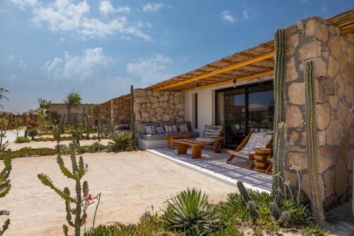 a patio of a house with a couch and a table at Marmarica Boutique Cabanas - Ras El Hekma - North Coast Top Rated Luxury Stay in Marsa Matruh