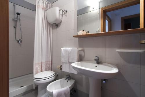 a white bathroom with a sink and a toilet at Villaggio Mare Si in Follonica