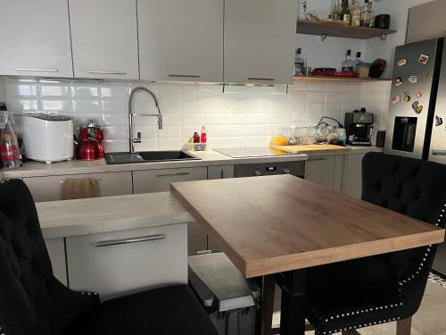 Il comprend une cuisine avec une table et des chaises en bois. dans l'établissement Une bulle de tranquillité, à Bordeaux