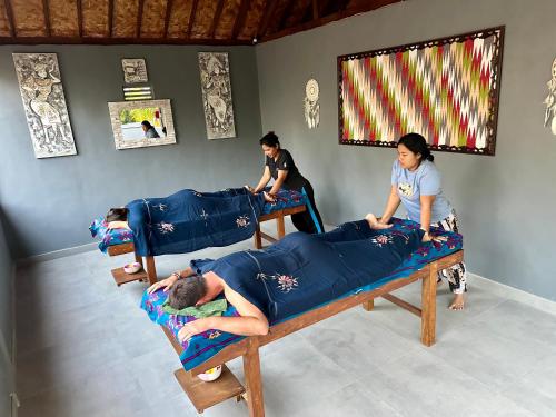 a group of people laying on beds in a room at Jungle Paradise in Nusa Penida