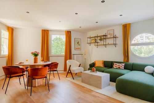 un salon avec un canapé vert et une table dans l'établissement Paris La Defense Design residence, à Courbevoie