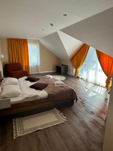 a bedroom with a large bed and a large window at Guest House Zatyshnyi Dvir in Bukovel