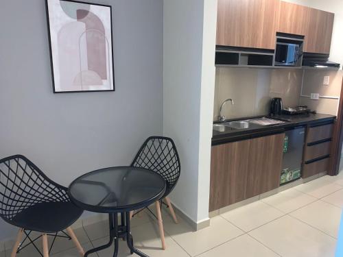 a small kitchen with a table and two chairs at Equipetrol Suites apart hotel in Santa Cruz de la Sierra