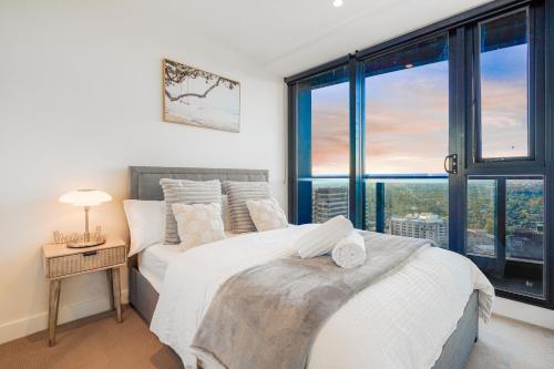 two beds in a bedroom with a window at Highrise Skyline Spectacular View Luxury 2B2B1C in Box Hill