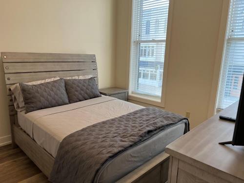 a bedroom with a bed and two windows at Strongback Suite 205 in Adrian