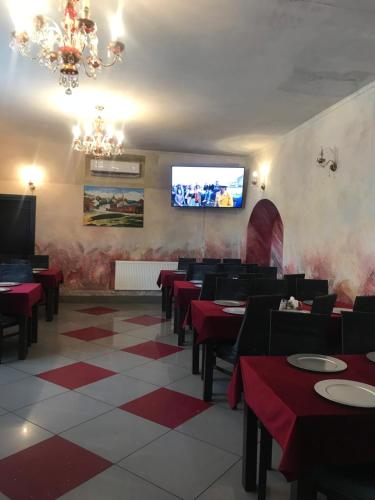 a dining room with red tables and a flat screen tv at Rezydencja Królewska in Sandomierz