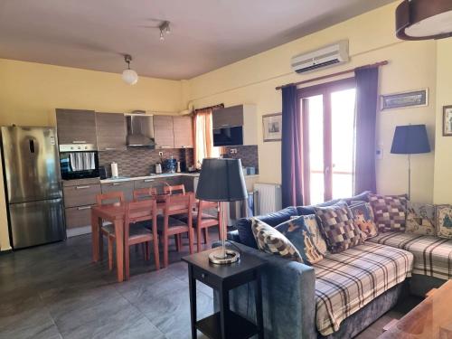 a living room with a couch and a table and a kitchen at Syros 41 in Ermoupoli
