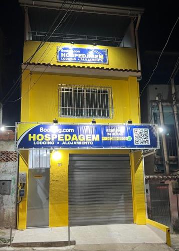 a yellow building with a sign on the side of it at Suite 3, Casa Amarela, Terceiro Andar in Nova Iguaçu