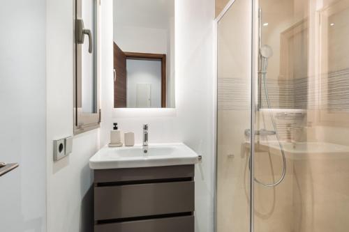 a white bathroom with a sink and a shower at Agora 0-3 DELUXE 1B in Palm-mar