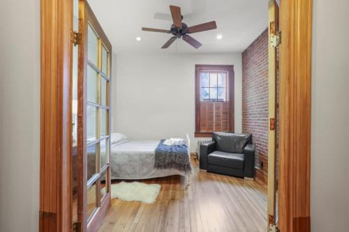 a bedroom with a bed and a fan and a chair at The Urban Oasis - 2 BR - Great Location in Columbus