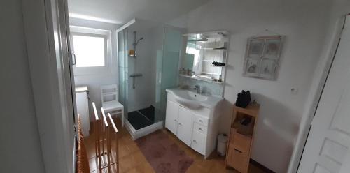 une salle de bain blanche avec un lavabo et un miroir dans l'établissement Maisonnette de plain pied, au Barcarès