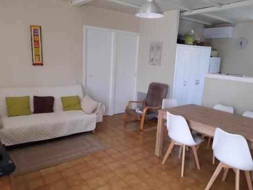 un salon avec une table et un canapé dans l'établissement Maisonnette de plain pied, au Barcarès