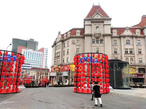 a person is standing in front of a building at Hua Qi Kaiserdom Hotel Zhongshan Road St Michael's Cathedral and Zhanqiao Pier Qingdao in Qingdao
