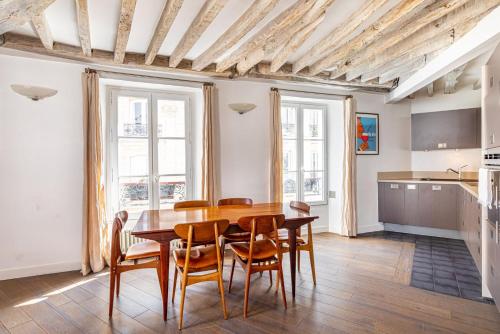 une cuisine et une salle à manger avec une table et des chaises en bois dans l'établissement GuestReady - Séjour confortable dans le 9ème, à Paris
