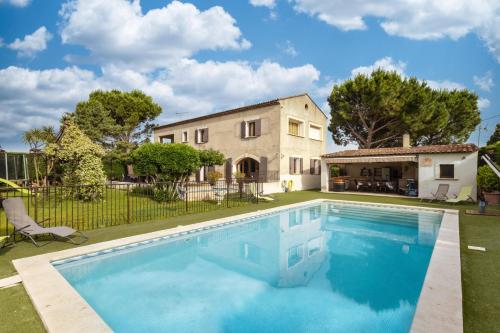 une grande piscine devant une maison dans l'établissement Monte Leon, à Châteaurenard