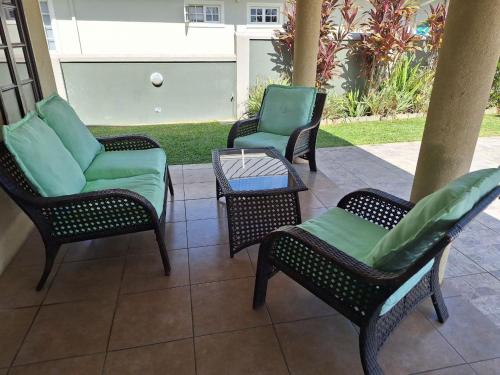 three chairs and a table on a patio at Driftwood 85 in Canaan