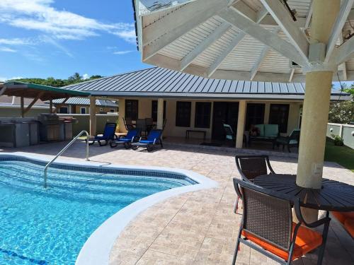 a swimming pool with chairs and a table and an umbrella at Driftwood 85 in Canaan