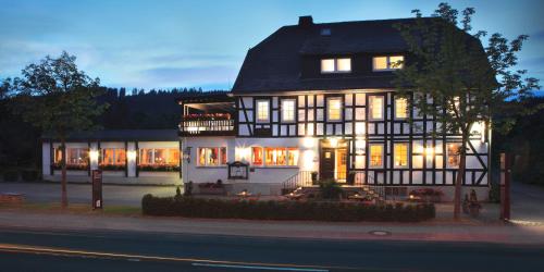 a large house with lights on in the night at Landgasthof Reinert in Reiste