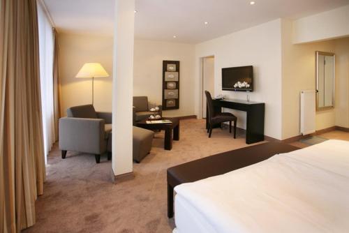 a hotel room with a bed and a living room at Hotel & SPA Waldecker Hof in Willingen