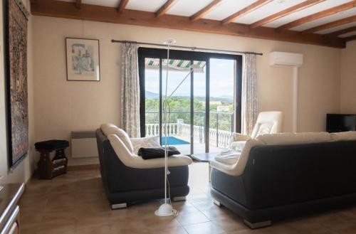 un salon avec deux canapés et un balcon dans l'établissement 34CANTA Le Cantagril, à Argelliers