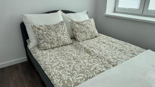 a bed with four pillows on top of it at Apartament Grójec in Grójec