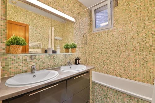 une salle de bain avec deux lavabos, un miroir et une baignoire dans l'établissement Appartement Quartier Saint Marcel Free Netflix, à Paris