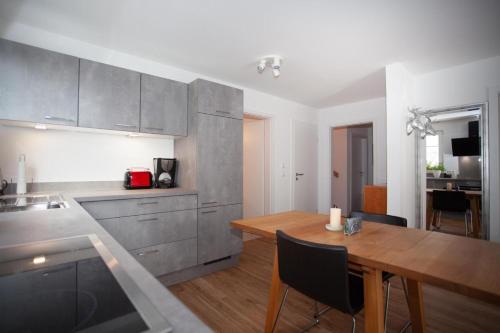 a kitchen with a wooden table and a dining room at Ferienwohnung Will in Bodman-Ludwigshafen