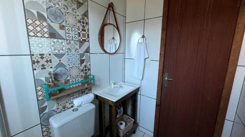 a small bathroom with a sink and a toilet at Morada das Orquídeas in Guarda do Embaú