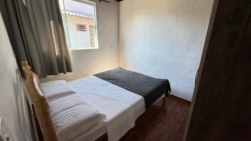 a small bed in a room with a window at Morada das Orquídeas in Guarda do Embaú