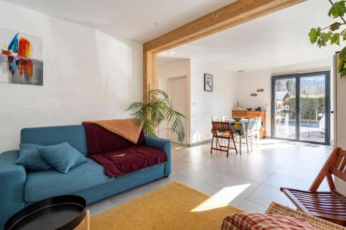 un salon avec un canapé bleu et une table dans l'établissement Appartement Verchaix 5min de Samoens Vallée Giffre, à Verchaix