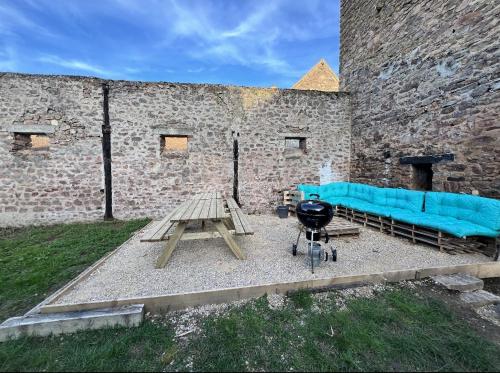 a picnic table and a blue couch in front of a building at "L'escargot" Maison familiale - Les Terres du Roy in Avallon
