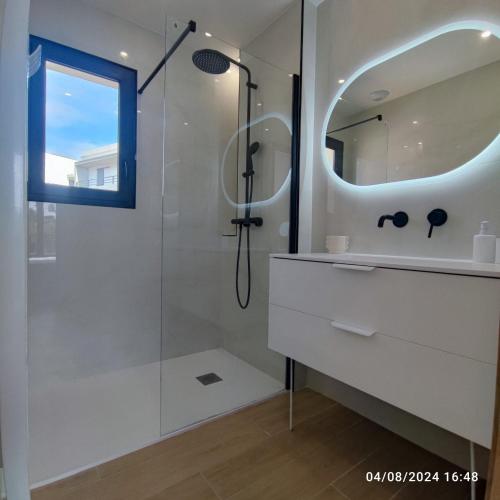 une salle de bain avec une douche, un lavabo et un miroir dans l'établissement Villa de standing climatisée, piscine & jacuzzi - 20' Cannes, à La Roquette-sur-Siagne