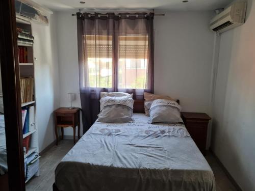 une chambre avec un grand lit avec une fenêtre dans l'établissement La maison Provençale avec Piscine, à Marseille