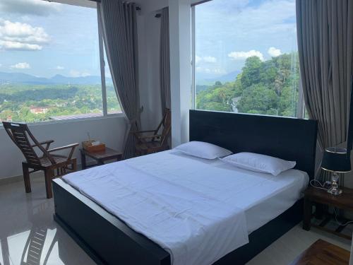 a bedroom with a bed and a large window at Galkaduwa360 Villa in Kandy