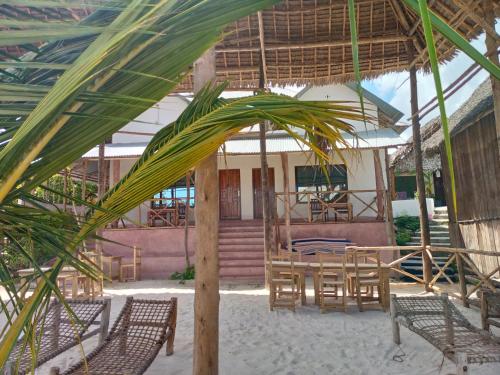 a room with a table and chairs and a building at Ndiro Beach House Kendwa in Kendwa