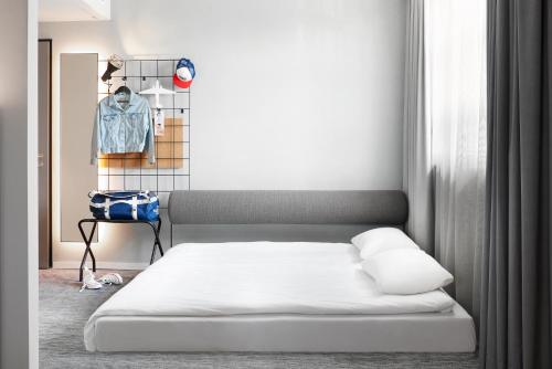 a bedroom with a bed and a rack of clothes at Moxy Cologne Muelheim in Cologne