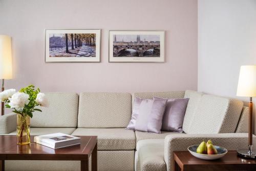 a living room with a couch and a table at GRAND ELYSEE Hamburg in Hamburg